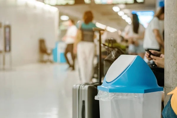 Blue cover transparent trashcan for increasing safety measures placed on the floor in the airport.