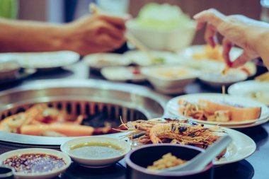 İnsanlar restoranda dumansız ızgarada et pişiriyor.. 