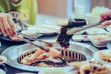 İnsanlar restoranda dumansız ızgarada et pişiriyor.. 