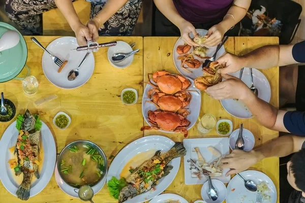 Вид на Счастье семьи наслаждаться едой с различными блюдами из морепродуктов на ужин. — стоковое фото