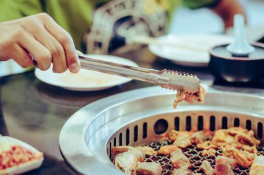 İnsanlar restoranda dumansız ızgarada et pişiriyor..