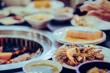 İnsanlar restoranda dumansız ızgarada et pişiriyor..