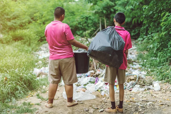 Estudiantes masculinos ayudan a eliminar la basura del aula para amontonar residuos . — Foto de Stock