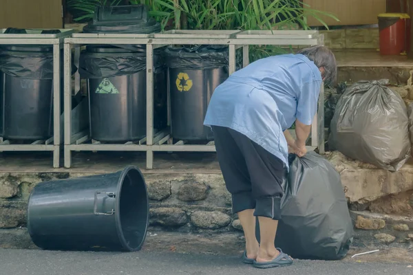 Trabajadora clasifica la basura y empacada en bolsas negras para mayor comodidad de transporte — Foto de Stock