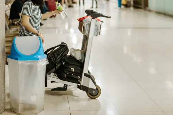 Blue cover transparent trashcan for increasing safety measures placed on the floor in the airport.