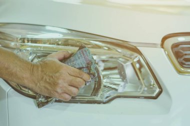 Erkek işçinin eline yakın arabanın cam kısmını temizlemek için ıslak gazete kullanın