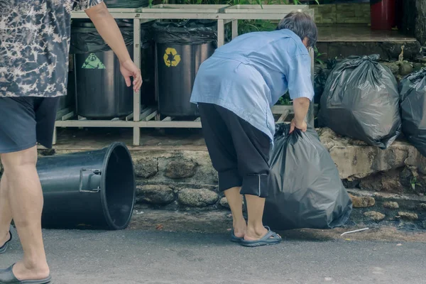 Trabajadora clasifica la basura y empacada en bolsas negras para mayor comodidad de transporte . — Foto de Stock