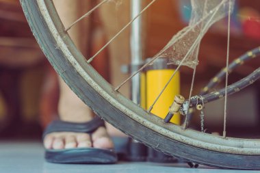 Genç bir adamın yakın çekimi eski bisiklet tekerleğini evinde pompalamaya hazır olun.. .