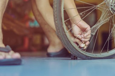 Genç bir adamın yakın çekimi eski bisiklet tekerleğini evinde pompalamaya hazır olun.. .