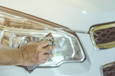 Erkek işçiye yakın mesafede, arabanın cam kısmını temizlemek için ıslak gazeteler kullanın. Eldeki seçici odaklanma.