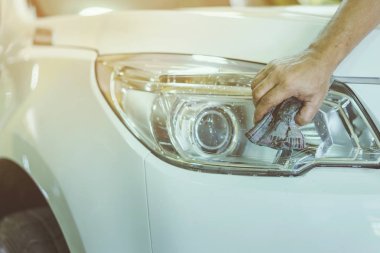 Erkek işçiye yakın mesafede, arabanın cam kısmını temizlemek için ıslak gazeteler kullanın. Eldeki seçici odaklanma.