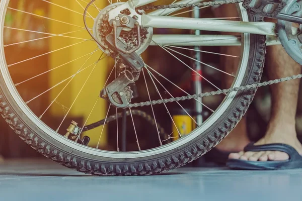 Genç bir adamın yakın çekimi eski bisiklet tekerleğini evinde pompalamaya hazır olun.. .