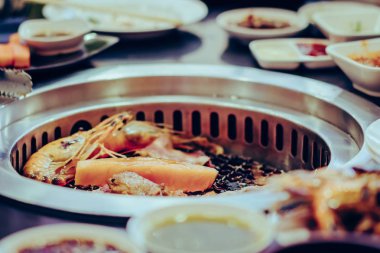 İnsanlar restoranda dumansız ızgarada et pişiriyor..