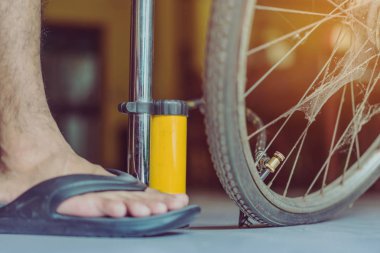 Genç bir adamın yakın çekimi eski bisiklet tekerleğini evinde pompalamaya hazır olun.. .