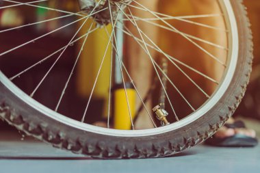 Genç bir adamın yakın çekimi eski bisiklet tekerleğini evinde pompalamaya hazır olun.. .