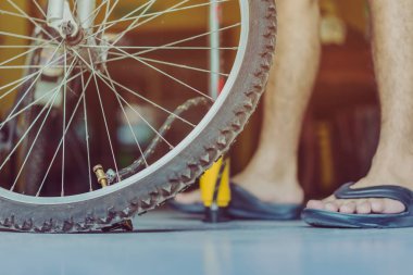 Genç bir adamın yakın çekimi eski bisiklet tekerleğini evinde pompalamaya hazır olun.. .