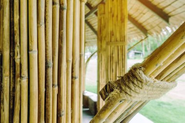 Birçok bambu bağı kenevir halatlarıyla birbirine bağlanır ve dinlenme kulübesi için sırık olarak kullanılır. Kenevir iplerine odaklan.