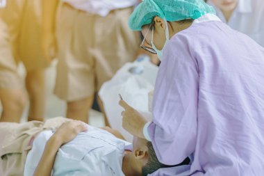 Dişçi, ağız aynası olan ve okulda araştırma yapan bir öğrencinin dişlerini inceliyor..