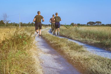 Akşamları pirinç tarlalarında birlikte koşan ve arkadaşlarıyla egzersiz yapan erkeklerin arka planı..