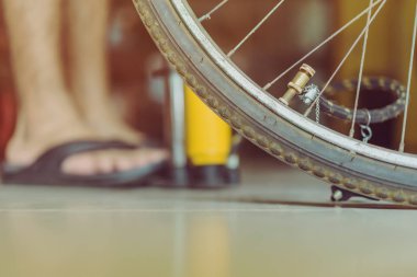 Genç bir adamın yakın çekimi eski bisiklet tekerleğini evinde pompalamaya hazır olun.. .