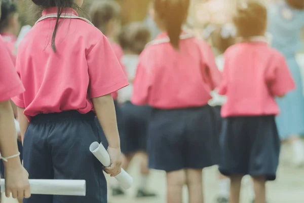 Wstecz widok małych dziewczynek używać rolki papieru zamiast długich kije cheerleaderka pałeczki na szkolnej paradzie marszu praktyki. — Zdjęcie stockowe