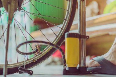 Genç bir adamın yakın çekim eski bisiklet tekerleği pompalama hazırlamak