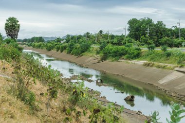 Beton duvardaki sulama kanalları su rezervuarından Tayland 'ın yağmur mevsiminde kuruyan çiftçinin tarım alanına su gönderir. Tarım sektöründe çevre felaketi