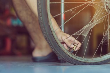 Genç bir adamın yakın çekimi eski bisiklet tekerleğini evinde pompalamaya hazır olun.. .