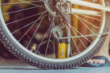 Genç bir adamın yakın çekimi eski bisiklet tekerleğini evinde pompalamaya hazır olun.. .