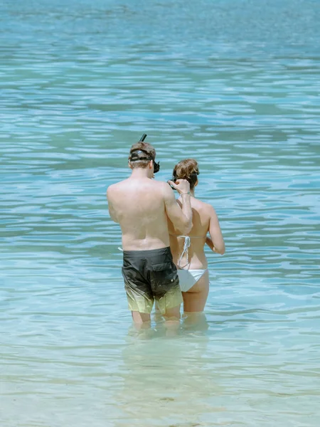 Dżentelmen pomagał ubrać okulary dla kochanka przed nurkowaniem, aby zobaczyć piękny koralowiec w morzu.. — Zdjęcie stockowe