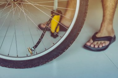 Genç bir adamın yakın çekimi eski bisiklet tekerleğini evinde pompalamaya hazır olun.. 