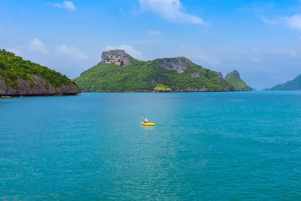 Kayak turístico en azul Océano turquesa idílico para explorar cerca de la isla con exuberantes árboles de selva verde y montañas de piedra caliza en el Parque Nacional Marino Ang Thong, Tailandia . — Foto de Stock