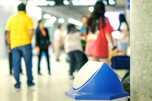 Blue cover transparent trashcan for increasing safety measures placed on the floor in the airport.