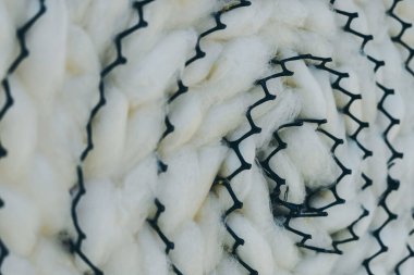 Siyah plastik örgü tepsisindeki doğal beyaz ipek böceği kozasına yakın. İpek böceği kozası arka planı.