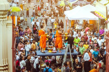 NAKHON THAILAND - NOVEMBER 16: Kimliği belirlenemeyen Tayland rahipleri, Tayland 'ın Nakhon Pathom kentinde Kasım 16.2019' da Wat Phra Pathommachedi 'de yapılan dini bir sadaka töreni olarak fakir / görgü tanıklarına kurdele-çiçek verdi.