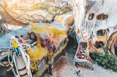 DALAT, VIETNAM. 26 Nisan 2019. Tanımlanamayan turistler 26 Nisan 2019 'da Dalat, Vietnam' daki Hang Nga Konuk Evi 'ne ziyarete geliyor. Vietnamlı kadın mimar Dang Viet Nga tarafından tasarlandı ve inşa edildi.