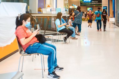 KANCHANABURI, THAILAND-MAY 13,2020: Kimliği belirsiz kişiler sandalyeye oturmuş ve Robinson 'da CoronaVirüs' ün (Covid-19) yayılmasının önlenmesi sırasında bankayla işlemlerin yapılmasını bekliyorlardı