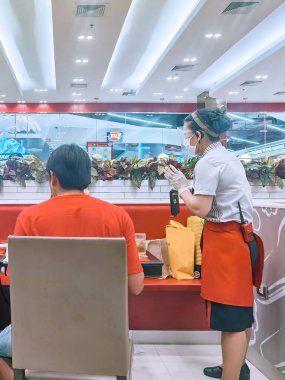 KANCHANABURI, THAILAND-JUNE 21 Haziran 2020: Corona virüsünün (Covid-19) Robinson alışveriş merkezindeki MK restoranında 21 Haziran 2020 'de Kanchanaburi, Tayland' da yayılmasını önlemek için yeni normallerle yemek yemek