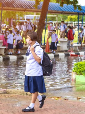 Kanchanaburi, Tayland-2 Temmuz 2020: Taylandlı öğrenciler okuldan sonra kendilerini Coronavirus 'tan (Covid-19) korumak ve KTR okulunda yağmur durduktan sonra evlerine dönmek için çeşitli tıbbi maskeler takıyorlar.