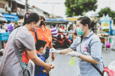 KANCHANABURI, THAILAND-MAYIS 23,2020: Yerel pazarda Coronavirus 'un (Covid-19) yayılmasını önlemek için alışverişe çıkmadan önce QR kod veya kayıt defteri kullanılarak vücut sıcaklığının incelenmesi ve kimlik kaydı