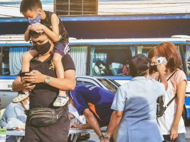 KANCHANABURI, THAILAND-JUNE 28,2020: Coronavirus 'un (Covid-19) yerel pazara yayılmasını önlemek için giriş öncesi QR kod veya kayıt defteri kullanılarak vücut sıcaklığının incelenmesi ve kayıt kimliği