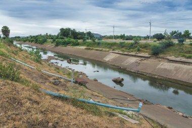 Beton duvardaki sulama kanalı ya da sulama kanalı Tayland 'ın yağmur mevsiminde kuruyan çiftçinin su rezervuarından tarım alanına su gönderin.. 