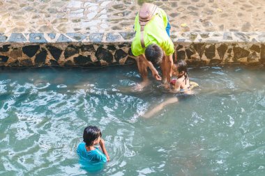 KANCHANABURI, THAILAND - 1 Ocak 2020 'de Kanchanaburi, Tayland' da kimliği belirlenemeyen Asyalı turistler cesedi sıcak maden suyuna batırıp sağlık için Hindad Hotspring 'te yıkandılar..