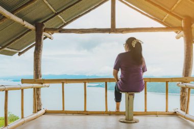 Kadın manzarası, Si Sawat Mahallesi, Kanchanaburi Tayland 'daki Srinagarind Barajı' nın yukarısında büyük bir rezervuarla doğanın güzel manzarasının keyfini çıkarıyor..