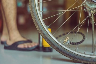 Genç bir adamın yakın çekimi eski bisiklet tekerleğini evinde pompalamaya hazır olun.. .