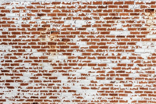 Background of old grunge brick wall texture with peeling plaster.