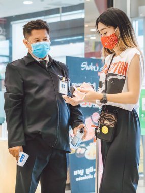 KANCHANABURI, THAILAND-11 Temmuz 2020: Güvenlik görevlisi, Robinson Mağazası girişinde Coronavirus 'u (Covid-19) önlemek için müşteriler için vücut termometresi ve alkol jeli enjeksiyon hizmetini kullanın