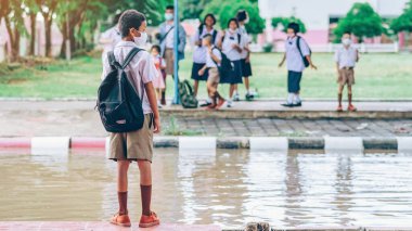 Kanchanaburi, Tayland-2 Temmuz 2020: Coronavirus 'un (Covid-19) okuldan sonra eve dönmesini engellemek için tanımlanamayan ilkokul öğrencileri maske takıyor ve KTR okulunda yağmur sadece duruyor.