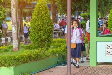 Kanchanaburi, Tayland-2 Temmuz 2020: Taylandlı öğrenciler okuldan sonra kendilerini Coronavirus 'tan (Covid-19) korumak ve KTR okulunda yağmur durduktan sonra evlerine dönmek için çeşitli tıbbi maskeler takıyorlar.