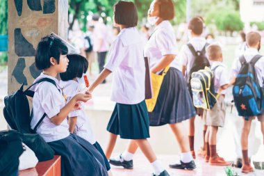 Kanchanaburi, Tayland-2 Temmuz 2020: Coronavirus 'un (Covid-19) okuldan sonra eve dönmesini engellemek için tanımlanamayan ilkokul öğrencileri maske takıyor ve KTR okulunda yağmur sadece duruyor.